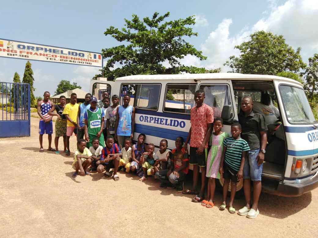 Enfants et personnels posant devant le bus